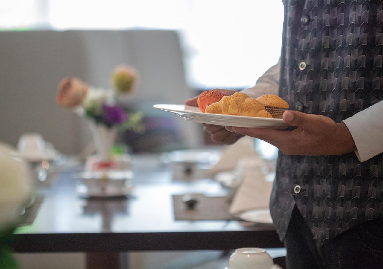 Holiday Suites Al Azizia Mecca ภายนอก รูปภาพ A waiter serving food at a buffet